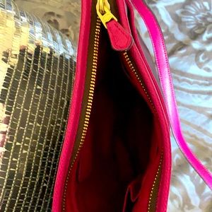 Dark chocolate Coach crossbody with purplish pink stitching .